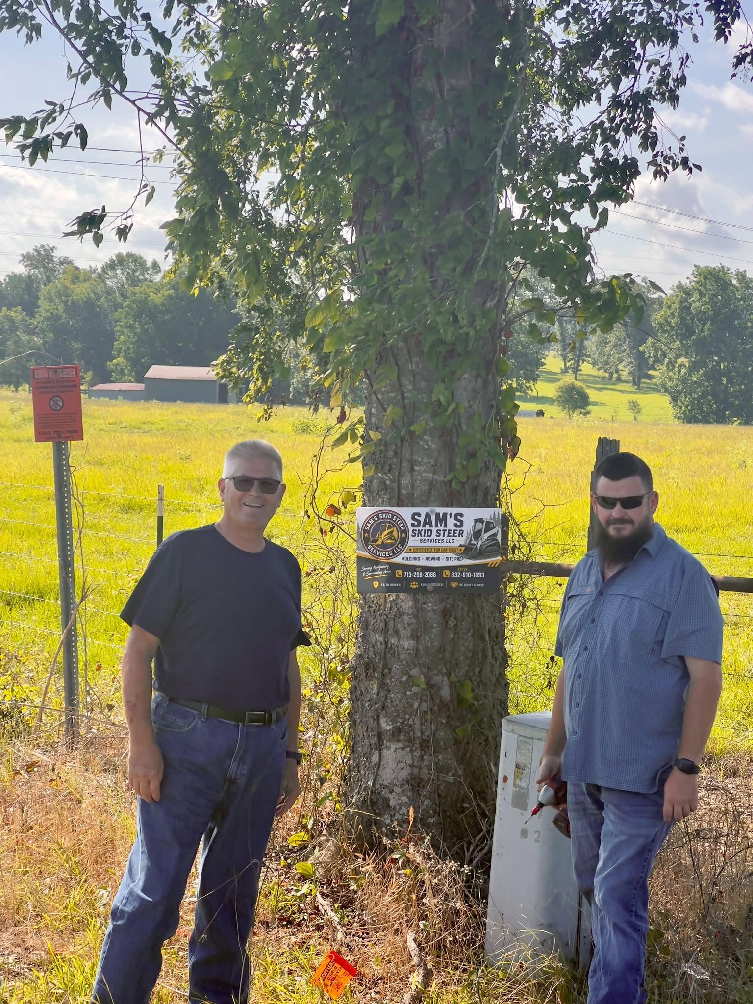 The team behind Sam's Skid Steer Services beside their sign in Montgomery County